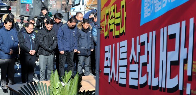 택시 4개 단체가 주축이 된 카풀 관련 비상대책위원회가 지난 12일 오전 서울 여의도 국회의사당 인근에 카카오 카풀앱 서비스에 항거해 분신 사망한 고 최우기 님 분향소를 설치한 뒤 묵념을 하고 있다. 뉴스1 © News1