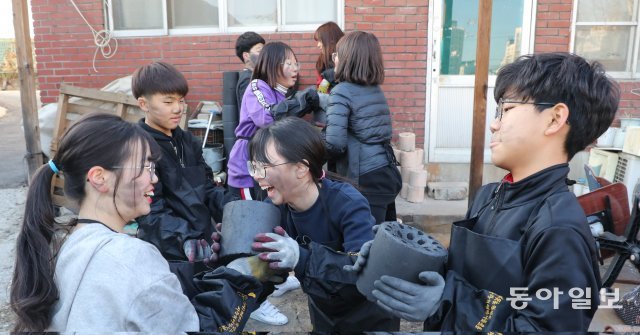 강추위가 시작된 12일 오후 서울 중랑구 신내초등학교 학생들이 추운 날씨에도 환하게 웃으며 길게 늘어서 연탄을 옮기고 있다. 연탄 배달은 보기보다 체력소모가 심해 아이들 이마에 금방 땀방울이 흘러내렸고 장갑을 낀 손 안도 땀으로 흥건해졌다. 김동주기자 zoo@donga.com