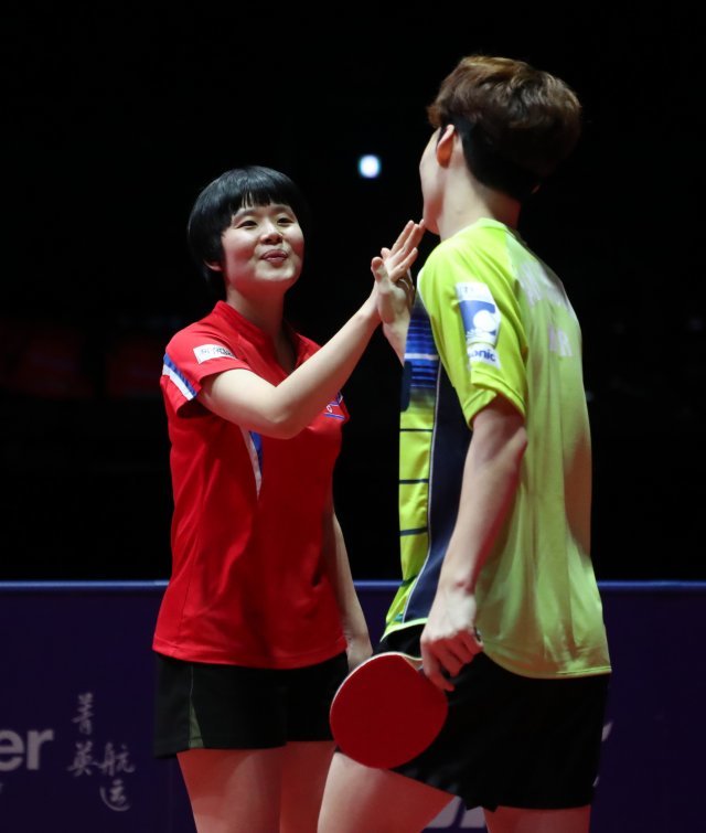 15일 오후 인천 남동체육관에서 열린 ‘2018 국제탁구연맹(ITTF) 월드투어 그랜드파이널스’ 혼합복식 결승전에서 남북단일팀 장우진과 북측 차효심이 홍콩의 웡춘팅과 두호이켐을 상대로 경기를 마치고 하이파이브를 하고 있다. 이날 장우진과 차효심은 홍콩조에 0대3으로 패해 준우승에 머물렀다. 2018.12.15/뉴스1 © News1