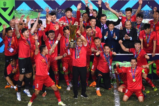 박항서 감독(가운데)이 15일(한국시간) 베트남 하노이의 미딩 국립경기장에서 2018 아세안축구연맹(AFF) 스즈키컵 우승 트로피를 들어 올리고 있다. © AFP=News1