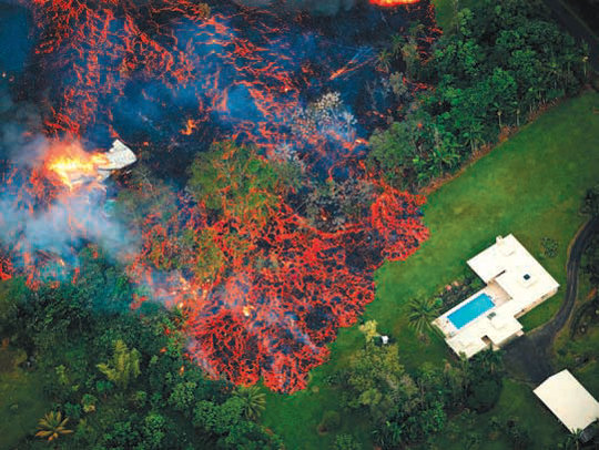 하와이섬(빅아일랜드)의 킬라우에아 화산 폭발로 흘러나온 용암이 주택가를 덮치고 있는 모습.
