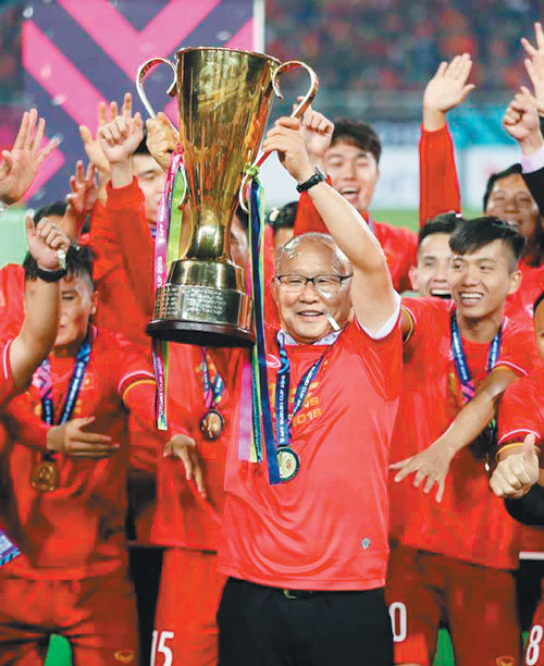 박항서 베트남 축구대표팀 감독(가운데)이 15일 베트남 하노이 미딘경기장에서 열린 말레이시아와의 2018 아세안축구연맹(AFF) 스즈키컵 결승 2차전 뒤 시상식에서 우승 트로피를 들어올리고 있다. 사진 출처 VN익스프레스