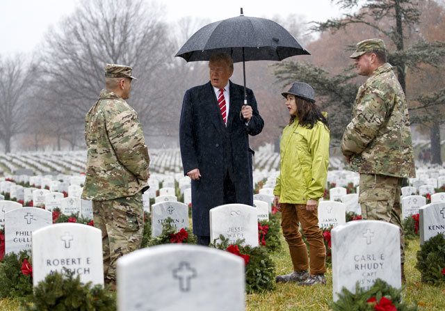 트럼프 국립묘지 깜짝 방문 15일 전미 헌화의 날을 맞아 버지니아주 알링턴국립묘지를 찾은 도널드 트럼프
 대통령(왼쪽에서 두 번째)이 직접 우산을 든 채 묘지 관리 군인과 대화하고 있다. 트럼프 대통령이 방문한 묘지 내 60구역은 
2001년 이후 아프가니스탄과 이라크 등지에서 벌어진 ‘테러와의 전쟁’ 전사자들이 안장된 곳이다. 알링턴=AP 뉴시스