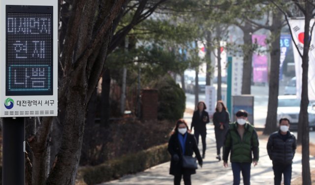 19일 오후 대전 서구청 앞에서 마스크를 착용한 시민들이 미세먼지 나쁨을 알리는 전광판을 지나고 있다. © News1