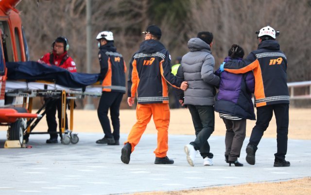 19일 강원 강릉시 종합운동장에서 강릉 펜션 사고 사망 학생 유가족이 아들의 이송 모습을 보고 있다. 지난 18일 강릉시 경포의 한 펜션에서 수능시험을 끝낸 서울 대성고 3학년 남학생 10명 중 3명이 숨지고 7명이 의식을 잃는 사고가 발생했다.2018.12.19/뉴스1 © News1