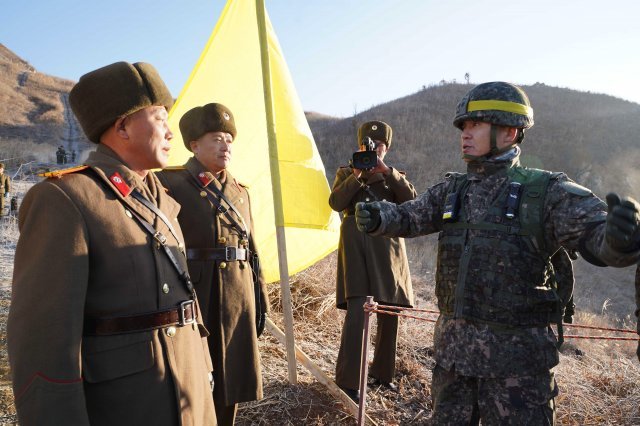 남북 군사당국이 ‘9·19 군사분야 합의서’ 이행 차원에서 시범철수한 비무장지대 내 GP(감시초소)에 대해 12일 오후 상호검증에 나선 가운데 강원도 철원 중부전선에서 남측 현장검증반이 북측 안내인원을 만나 인사를 하고 있다. 현장검증반은 이날 남북 시범철수 GP를 연결하는 오솔길을 통해 이동했고 오전에 우리측이 북측 GP 철수현장을, 오후에는 북측이 우리측 GP 철수현장을 각각 방문해 검증했다. 남북이 1953년 7월 정전협정 체결 이후 비무장지대 내에 설치된 GP를 상호 방문해 들여다보는 것은 이번이 처음이다. 앞서 남북은 ‘9·19 군사합의서’에 따라 지난달 말까지 시범철수 대상 GP 각각 11개 중 10개를 완전파괴했고, 1개씩은 병력과 장비는 철수하되 원형을 보존했다.(국방부 제공)