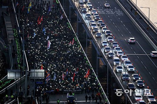 20일 오후 서울 영등포구 여의도 국회 인근에서 ‘카카오 카풀 반대’ 제3차 택시 생존권 사수 결의대회를 마친 택시기사들이 스마트폰 불빛을 켜고 마포대교를 건너고 있다. 안철민 기자 acm08@donga.com