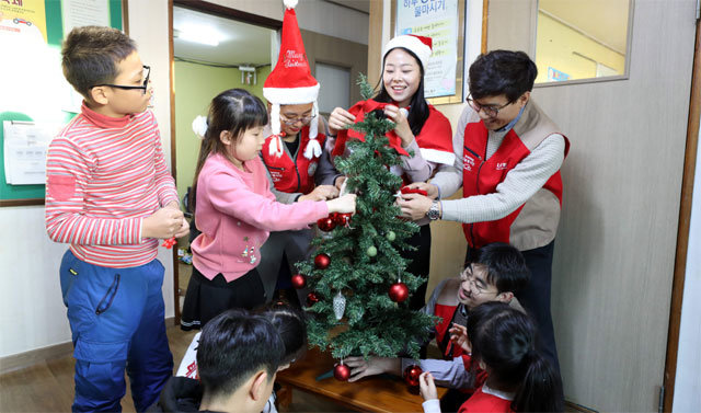 롯데백화점 광주점 샤롯데봉사단원들이 14일 광주 동구 한마음지역아동센터를 찾아 아이들과 함께 트리를 장식하고 있다. 롯데백화점 광주점 제공