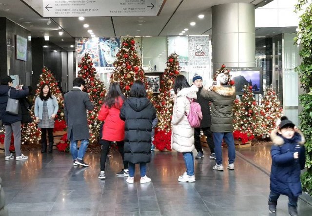 크리스마스 이브인 24일 오후 서울 중구 서울시청에 설치된 크리스마스 트리 앞에서 시민들이 사진을 찍고 있다. 2018.12.24/뉴스1 © News1