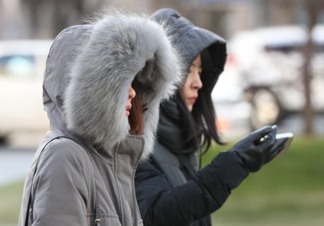 세밑한파가 몰아친 26일 오후 서울 광화문광장에서 두꺼운 옷을 입은 시민들이 발걸음을 재촉하고 있다. 기상청은 이날 오후부터 찬바람이 불면서 기온이 급격히 떨어지고면서 내일 서울 아침 최저기온이 영하 12도까지 떨어질 것으로 예보했다. © News1