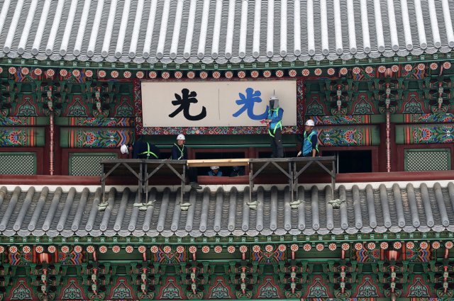 문화재청 직원들이 지난해 9월 27일 서울 광화문에서 광화문 현판 색상 분석 연구를 위한 실물 크기 실험용 현판을 설치하고 있다. 2017.9.27/뉴스1 © News1