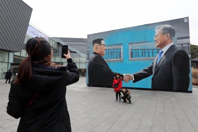 21일 서울 종로구 청와대 사랑채에서 ‘어서와 봄’을 주제로 개막한 ‘청와대x아티스트 콜라보전’을 찾은 아이들이 남북정상의 악수 모습이 담긴 작품 앞에서 기념촬영을 하고 있다.2018.12.21/뉴스1 © News1