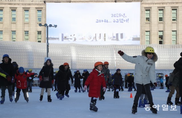 2018년 마지막 휴일인 30일 오전 서울시청앞에 마련된 스케이트장을 찾은 시민들이 시청앞 벽에 내걸린 “2018년 고마워.수고했어”를 배경으로 스케이트를 타고 있다.  김동주 기자 zoo@donga.com