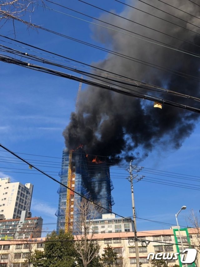 30일 오전 11시48분쯤 부산 사하구 하단동의 한 신축아파트 공사장에서 불이 나 한 시간여만에 진화됐다. 신축아파트 상층부에서 시꺼먼 연기와 불길이 치솟고 있다.(부산지방경찰청 제공)ⓒ News1