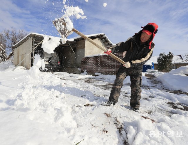 서해안 지역에 함박눈이 내린 30일 전남 영광군 법성면의 한 마을에서 주민이 발목까지 잠기는 눈을 쓸어내고 있다. 영광=박영철 기자 skyblue@donga.com