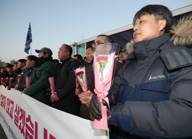 31일 오전 경기도 평택시 쌍용자동차 본사 앞에서 열린 복직 출근 기자회견에서 복직하는 해고노동자들이 선물 받은 카네이션을 들고 있다. 쌍용자동차 해고노동자 119명 중 남은 48명은 합의서에 따라 2019년 상반기에 복직한다. 2018.12.31/뉴스1 © News1 오장환 기자