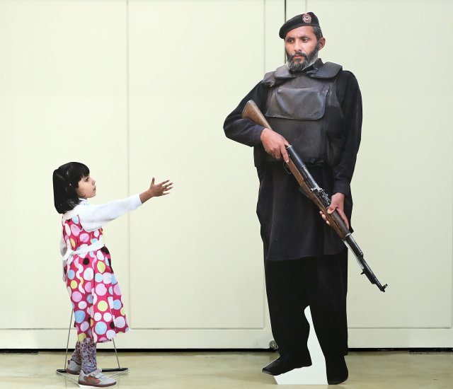 경찰에게 손을 내미는 어린이 / Anja Niedringhaus 2012년 / 파키스탄