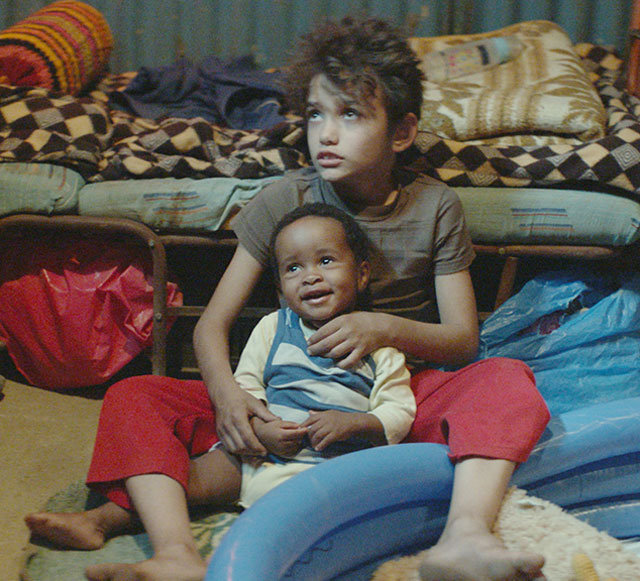 ‘가버나움’에서 12세 소년 자인이 엄마를 잃은 에티오피아인 아기 요나스를 키우는 장면. 영화는 빈곤 속에 사는 아이들의 처참한 삶을 통해 어른과 사회, 국가의 역할을 묻는다. 그린나래미디어 제공