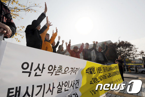 17일 오전 광주 법원 앞에서 전북 익산 약촌오거리 택시기사 살인사건 재심 청구인과 변호인 등이 무죄를 선고 받은 뒤 만세를 외치고 있다.2016.11.17/뉴스1 ⓒ News1