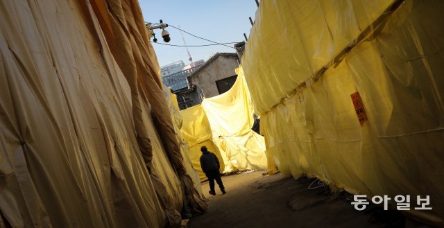 18일 오후 서울 청계천변 입정동 ‘공구 거리’에 철거 예정인 건물들이 노란 천에 쌓여 있다. 송은석 기자 silverstone@donga.com
