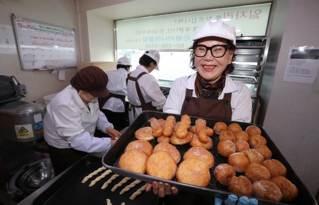 15일 오후 서울 은평구 꽈배기나라에서 점장 안국희 씨(74·여)가 갓 구워낸 꽈배기와 찹쌀 도넛을 들고 미소 짓고 있다. 이곳에서 꽈배기와 도넛을 만드는 6명은 모두 70세가 넘는 어르신들이다. 김동주기자 zoo@donga.com