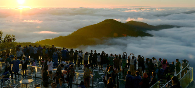 해발 1088m에 마련된 운카이 테라스에서 장엄하게 펼쳐진 구름바다 위로 해가 뜨고 있는 모습을 수많은 사람들이 지켜보고 있다. 2018년 8월. 아사히신문 제공