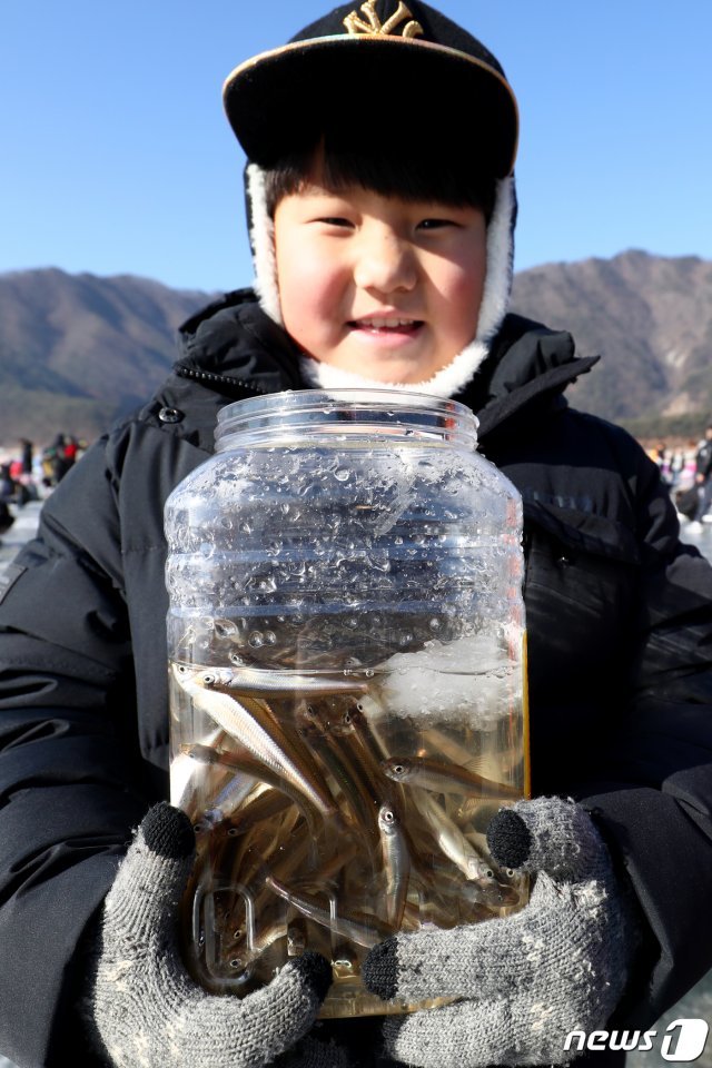 제19회 인제빙어축제 개막일인 26일 강원 인제군 남면 빙어호 얼음 위에서 한 아이가 빙어를 넣은 통을 들고 기뻐하고 있다. 2019.1.26/뉴스1 © News1 김경석 기자