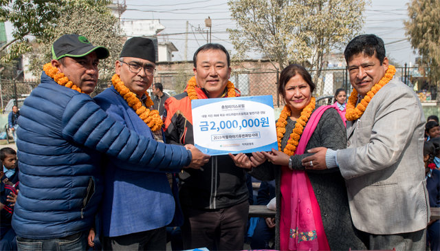 네팔의 수도 카트만두 인근에 있는 바드라칼리 초등학교를 찾은 ‘2019 히말라야 기후변화탐사대’가 이 학교에 지원금을 전달한 뒤 기념촬영을 하고 있다. 2019히말라야기후변화탐사대 제공