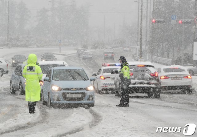 31일 제주산지를 중심으로 많은 눈이 내리고 있다. 제주시 아라동 제주대학교 입구에서 자치경찰이 차량을 통제하고 있다. © News1