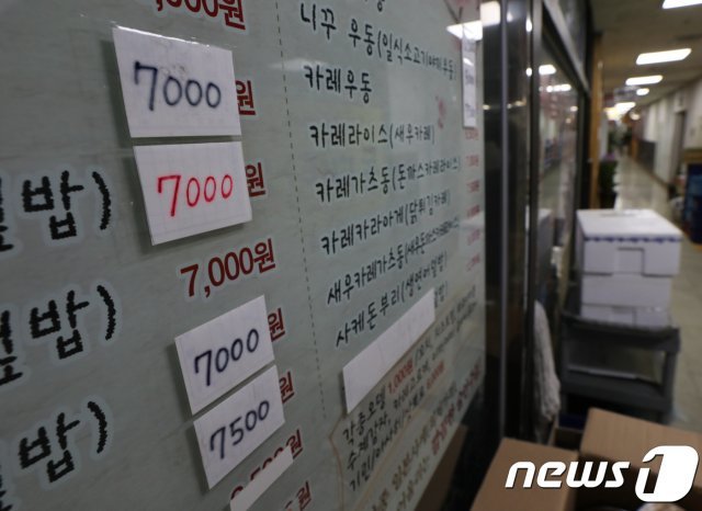 서울 도심의 한 식당의 창문에 인상된 가격이 붙어 있다.  © News1