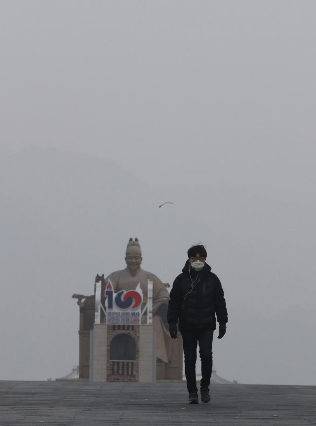 미세먼지 비상저감조치가 발령 됐던 지난달 15일 한 시민이 마스크를 쓴 채 서울 종로구 광화문 광장을 걷고 있다. 뉴시스