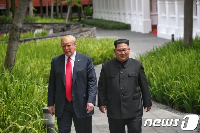 김정은 북한 국무위원장과 도널드 트럼프 미국 대통령이 12일 싱가포르 센토사 섬 카펠라호텔에서 오찬을 한 뒤 정원을 산책하고 있다. (싱가포르통신정보부 제공)2018.6.12/뉴스1