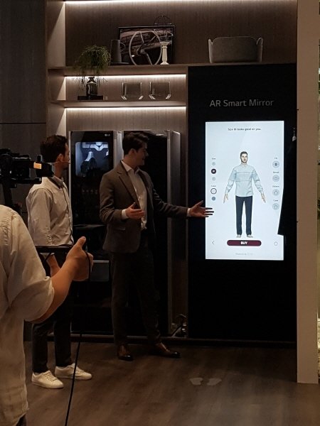 LG전자 부스에서 한 직원이 관람객들에게 ‘AR Smart Mirror‘ 데모를 진행하고 있다.