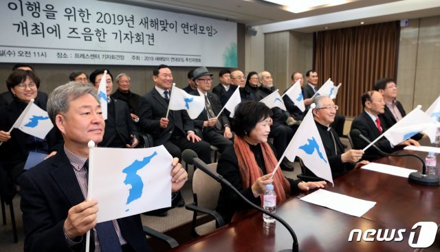 30일 오전 서울 중구 한국프레스센터에서 열린 남북공동선언 이행을 위한 2019년 새해맞이 연대모임 개최에 즈음한 기자회견에서 참석자들이 한반도기를 흔들고 있다. © News1