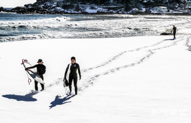서핑을 마친 여성 서퍼들이 눈 덮인 해변을 걸어 나오고 있다. 양회성 기자 yohan@donga.com