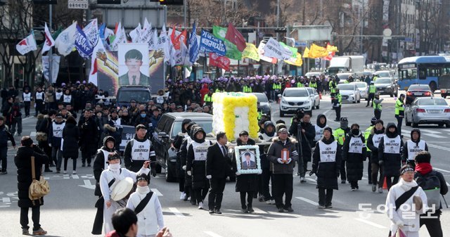 비정규직 노동자 고 김용균 씨의 영정 사진을 앞세운 운구행렬이 9일 오후 서울 중구 세종대로에서 노제를 마친 뒤 영결식 장소인 광화문광장 쪽으로 이동하고 있다. 장승윤 기자 tomato99@donga.com