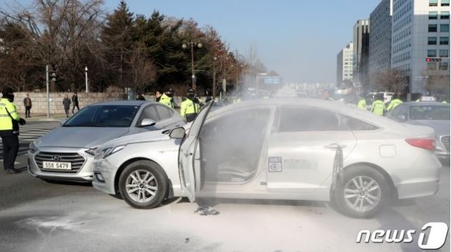 사진=11일 오후 서울 여의도 국회 정문앞에서 한 택시기사가 분신을 시도해 경찰들이 화재진압을 하고 있다(뉴스1)