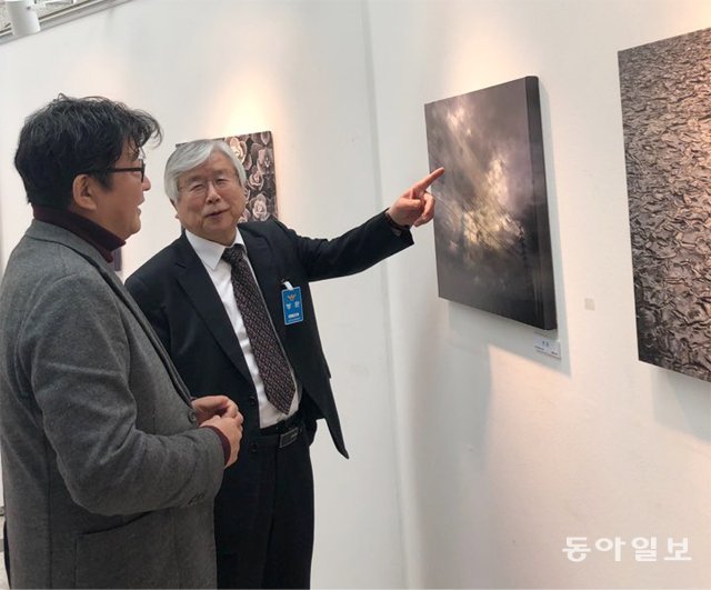 8일 인천경찰청 1층 미추홀갤러리에서 열리고 있는 ‘생각 속에 갇힌 세상’ 전시회를 찾은 이경호 대한적십자사 인천지사 회장(오른쪽)이 김노천 작가에게서 작품 설명을 듣고 있다. 박희제 기자 min07@donga.com