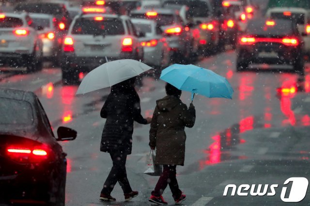 11일 오후 대구 일부 지역에 내리던 눈이 진눈깨비로 바뀌자 우산을 쓴 시민들이 발걸음을 재촉하고 있다. 2018.12.11/뉴스1 © News1