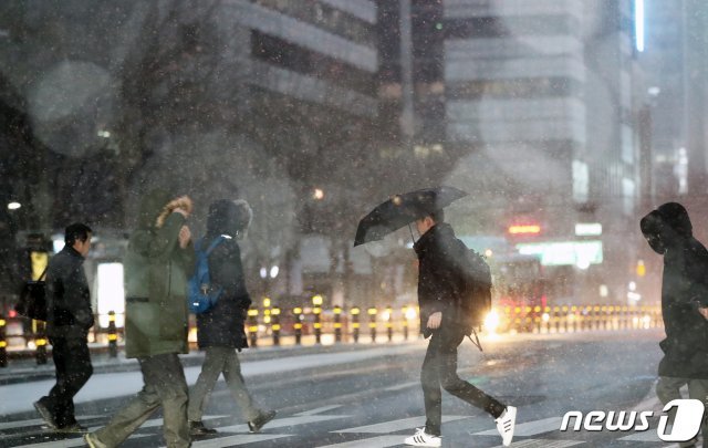 기습 함박눈이 내린 15일 오전 서울 종각역 네거리에서 시민들이 출근길 발걸음을 재촉하고 있다. 중부지방을 중심으로 모처럼 내린 눈은 아침까지 이어진 뒤, 늦은 오후부터 다시 내릴 것으로 보인다. 2019.2.15/뉴스1 © News1