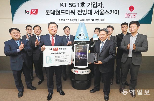 5G 첫 전파를 발사한 지난해 12월 1일 서울 송파구 잠실 롯데타워에서 KT 및 롯데월드 관계자들이 KT 5G 1호 가입자가 된 AI 로봇 ‘로타’와 기념촬영을 하고 있다.