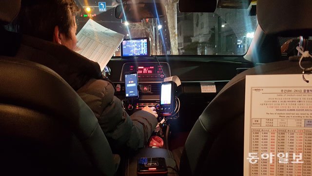 서울시 택시요금 인상 이틀째인 17일 승객을 태운 택시기사가 조견표(요금 변환표)를 보면서 인상 요금을 확인하고 있다. 서울시 택시요금은 16일 오전 4시부터 올랐지만 대부분의 택시 미터기에는 인상 전 요금이 표시돼 승객들이 불편을 겪었다. 구특교 기자 kootg@donga.com