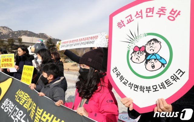 한산초등학교 비상대책위원회원들과 환경보건시민센터를 비롯한 시민단체 회원들이 18일 오전 서울 종로구 청와대 분수대 앞에서 석면폐기물 불법반출 아파트 재건축 현장 고발 기자회견을 갖고 있다. 2019.2.18/뉴스1 © News1