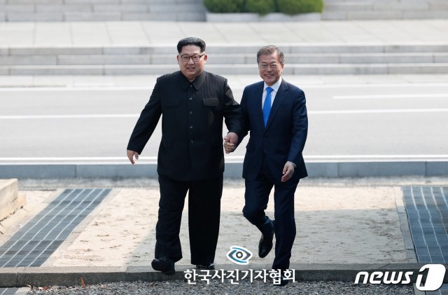 한국사진기자협회 제55회 한국보도사진상 대상에 동아일보 원대연 기자의 사진이 선정됐다. 지난해 4월 27일 문재인 대통령과 김정은 북한 국무위원장이 남북정상회담이 열린 판문점에서 만나 손을 잡고 함께 군사분계선을 넘는 모습. (한국사진기자협회 제공) 2019.2.18/뉴스1