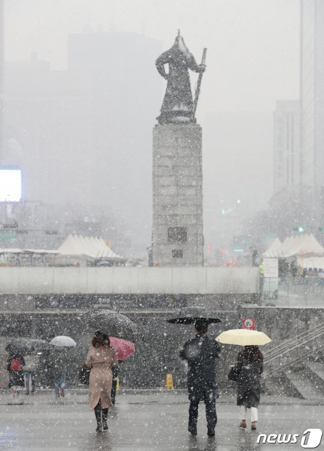 전국적으로 눈이 내린 19일 오전 서울 광화문네거리에서 출근하는 시민들이 눈을 맞으며 출근하고 있다. © News1