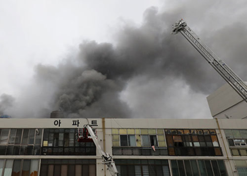 19일 오전 7시경 대구 중구 포정동 주상복합건물 4층 대보사우나에서 불이 나 검은 연기가 솟아오르고 있다. 이 불로 2명이 숨지고 81명이 다쳤다. 대구=뉴스1