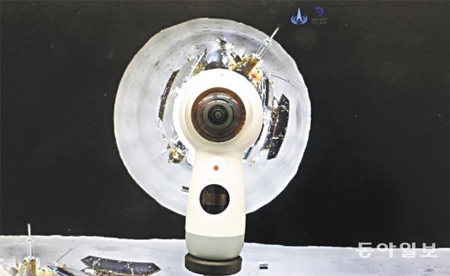 사진 중앙에 ‘외계인의 눈’처럼 생긴 기계가 보급형으로 나온 360도 카메라이고, 배경은 창어 4호에서 찍은 달 뒷면의 360도 사진이다. 장승윤 기자 tomato99@donga.com
