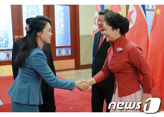 리설주 여사(왼쪽) 펑리위안 여사가 중국 인민대회당에서 인사를 나누고 있는 모습. (노동신문) / 뉴스1