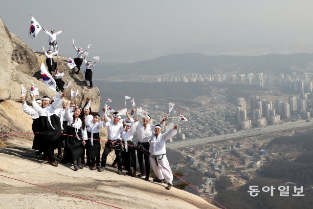 서울 도심이 한 눈에 바라보이는 불암산 정상에서 유관순과 독립운동가로 변신한 21명의 암벽등반가들이 퍼포먼스를 펼치고 있다.