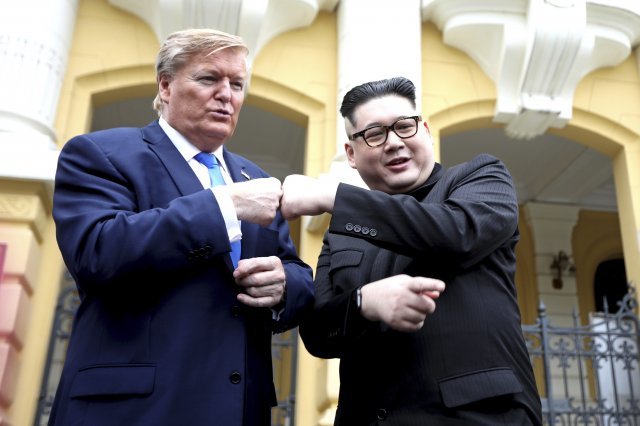 22일(현지시간) 도널드 트럼프 미국 대통령으로 분장한 러셀 화이트(왼쪽)와 김정은 북한 국무위원장으로 분장한 하워드 엑스가 베트남 하노이 오페라 하우스 앞에서 정상회담의 분위기를 띄우며 포즈를 취하고 있다. 하노이=AP/뉴시스